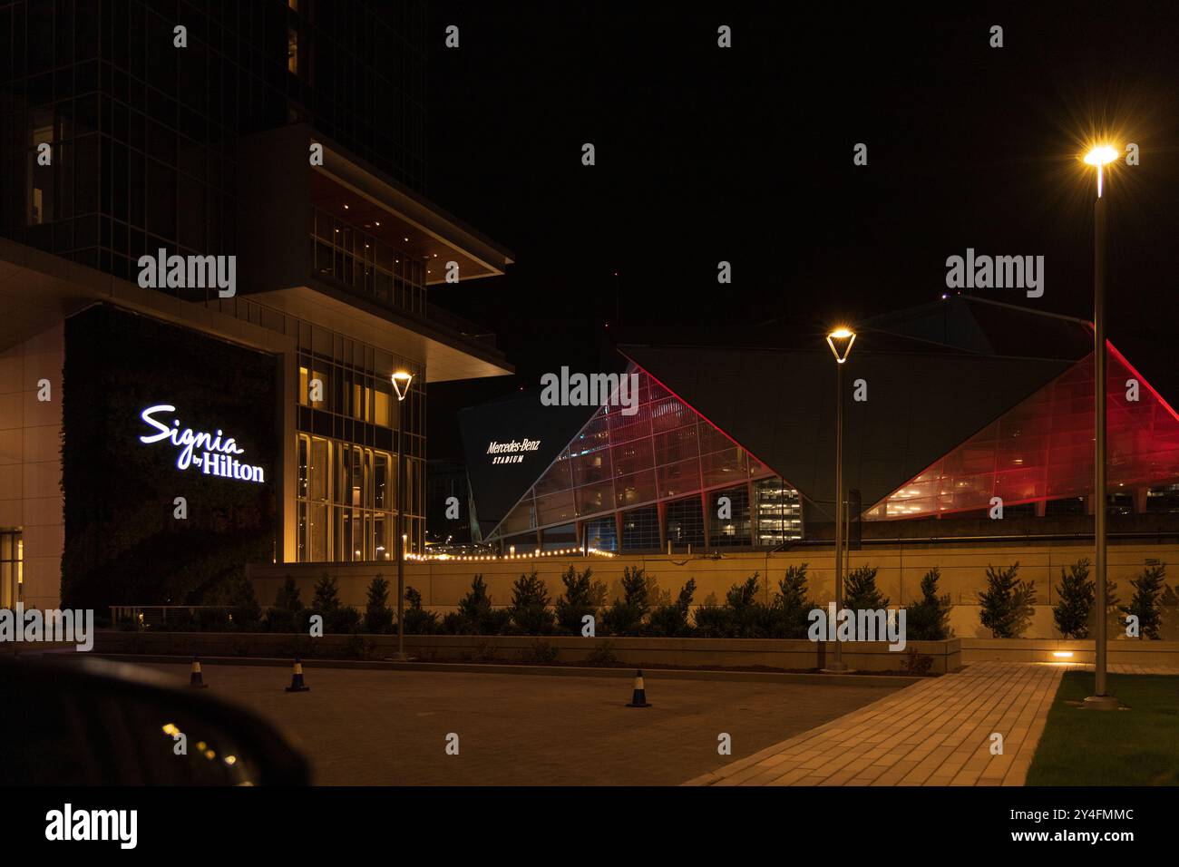 Una lobby dell'hotel con un grande cartello che dice "Signa". La lobby e' illuminata di notte, donandole un'atmosfera calda e invitante Foto Stock
