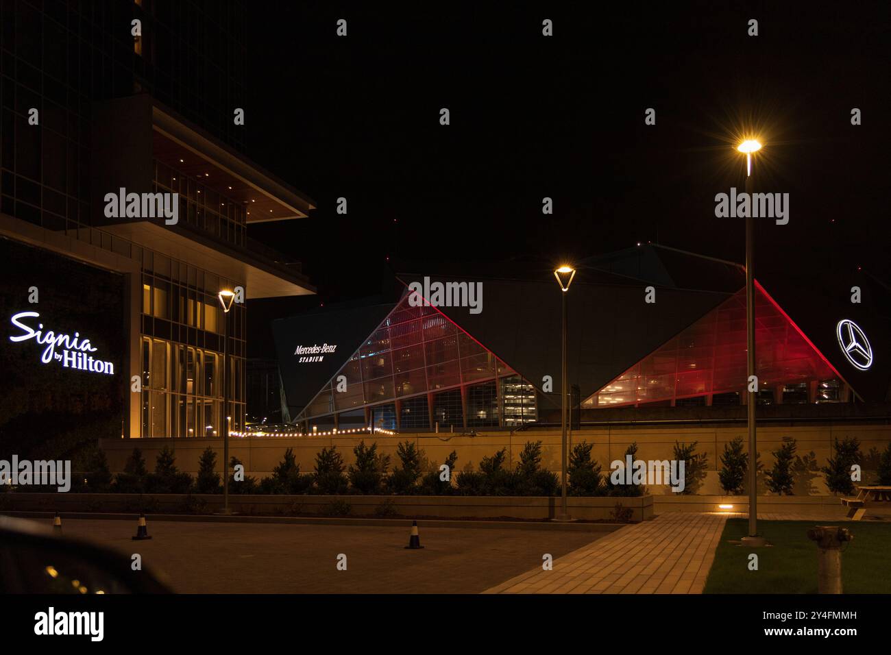 Un grande edificio con un cartello che dice 'Signia Hilton'. L'edificio e' illuminato di notte, donandogli un'atmosfera calda e invitante Foto Stock