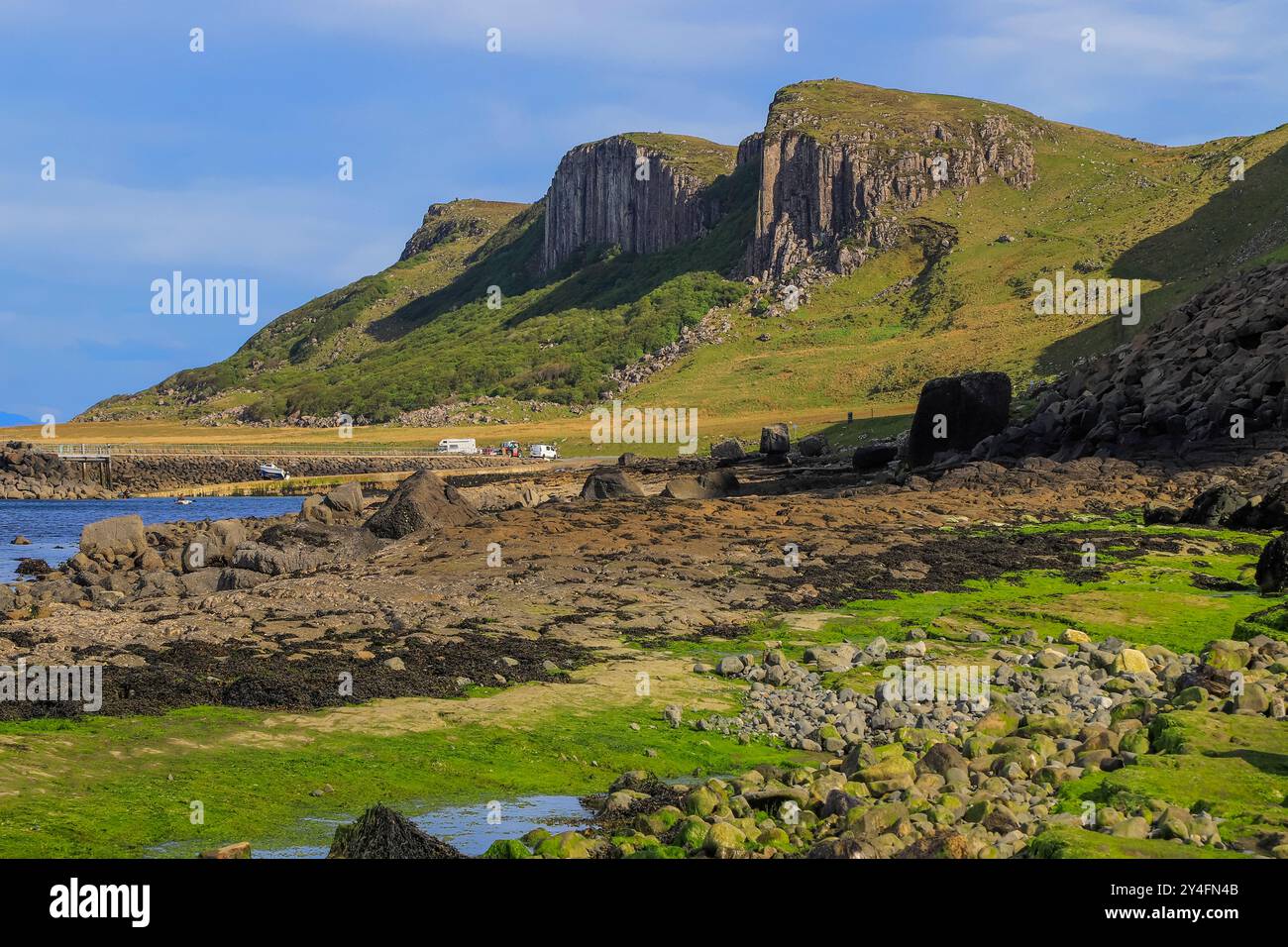 Scogliere ignee colonnari oltre una spiaggia di Corran, famose per la sabbia e l'impronta dei dinosauri. An Corran, Staffin, Trotternish, Skye, Scozia, REGNO UNITO Foto Stock