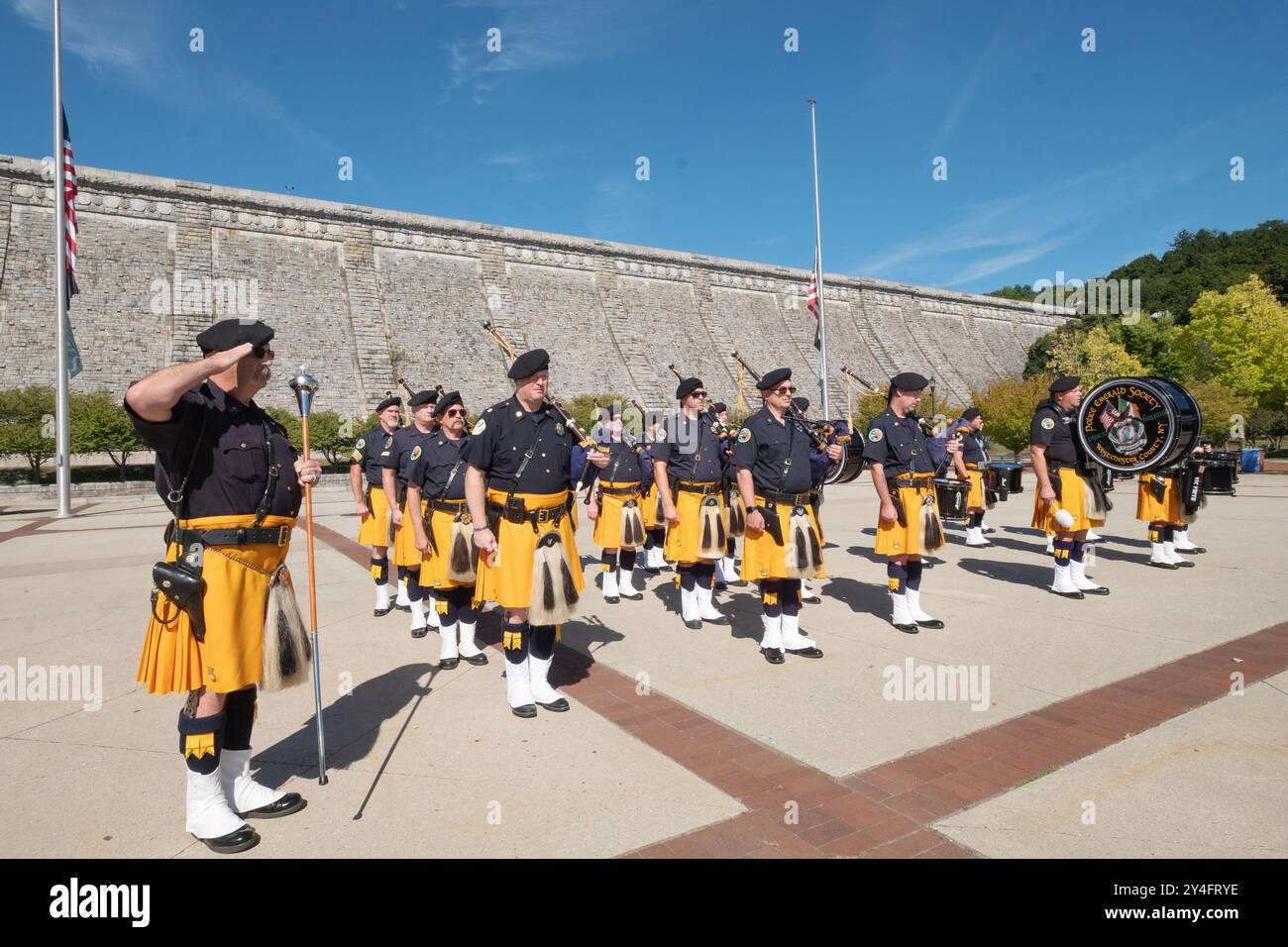 Le pipe e i tamburi della Police Emerald Society di Westchester salutano durante il canto dell'inno nazionale in una cerimonia commemorativa del 911 a Valhalla. Foto Stock