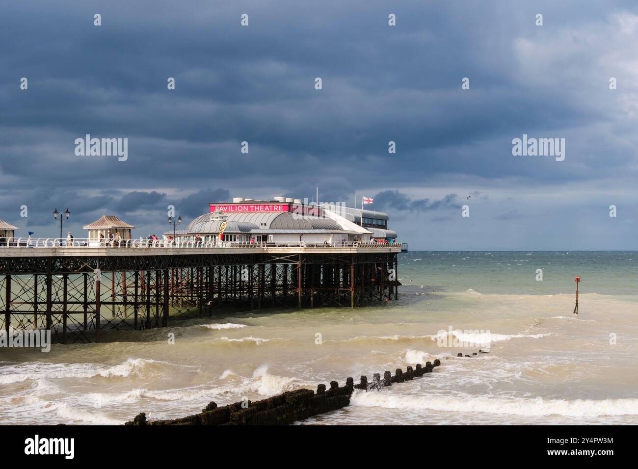 Vista dal lungomare al molo sotto un cielo nuvoloso scuro. Cromer, Norfolk, East Anglia, Inghilterra, Regno Unito, Regno Unito Foto Stock