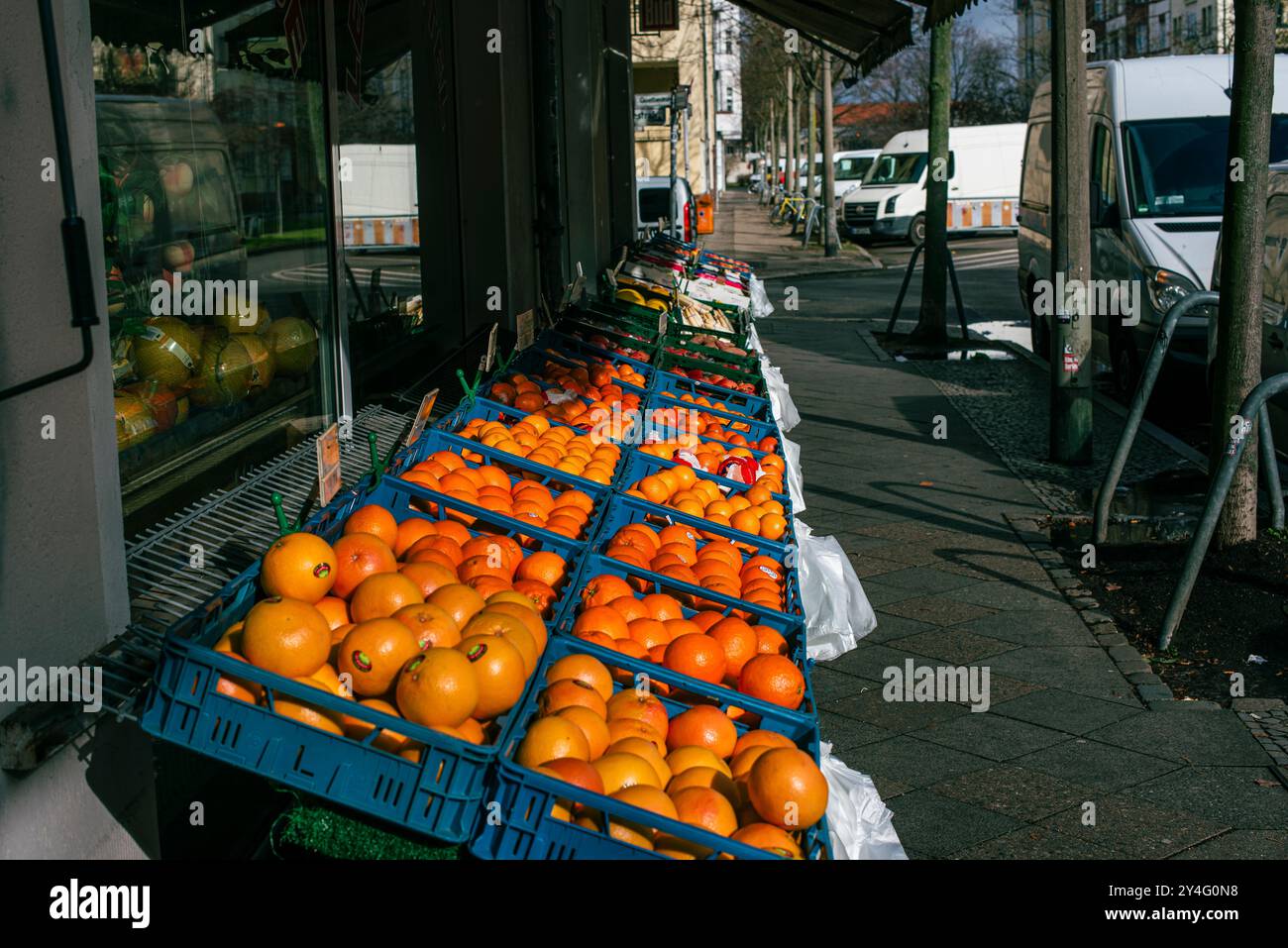 Un banco di frutta con un sacco di arance sul marciapiede, un negozio di frutta, un marciapiede e molte arance nei cesti Foto Stock