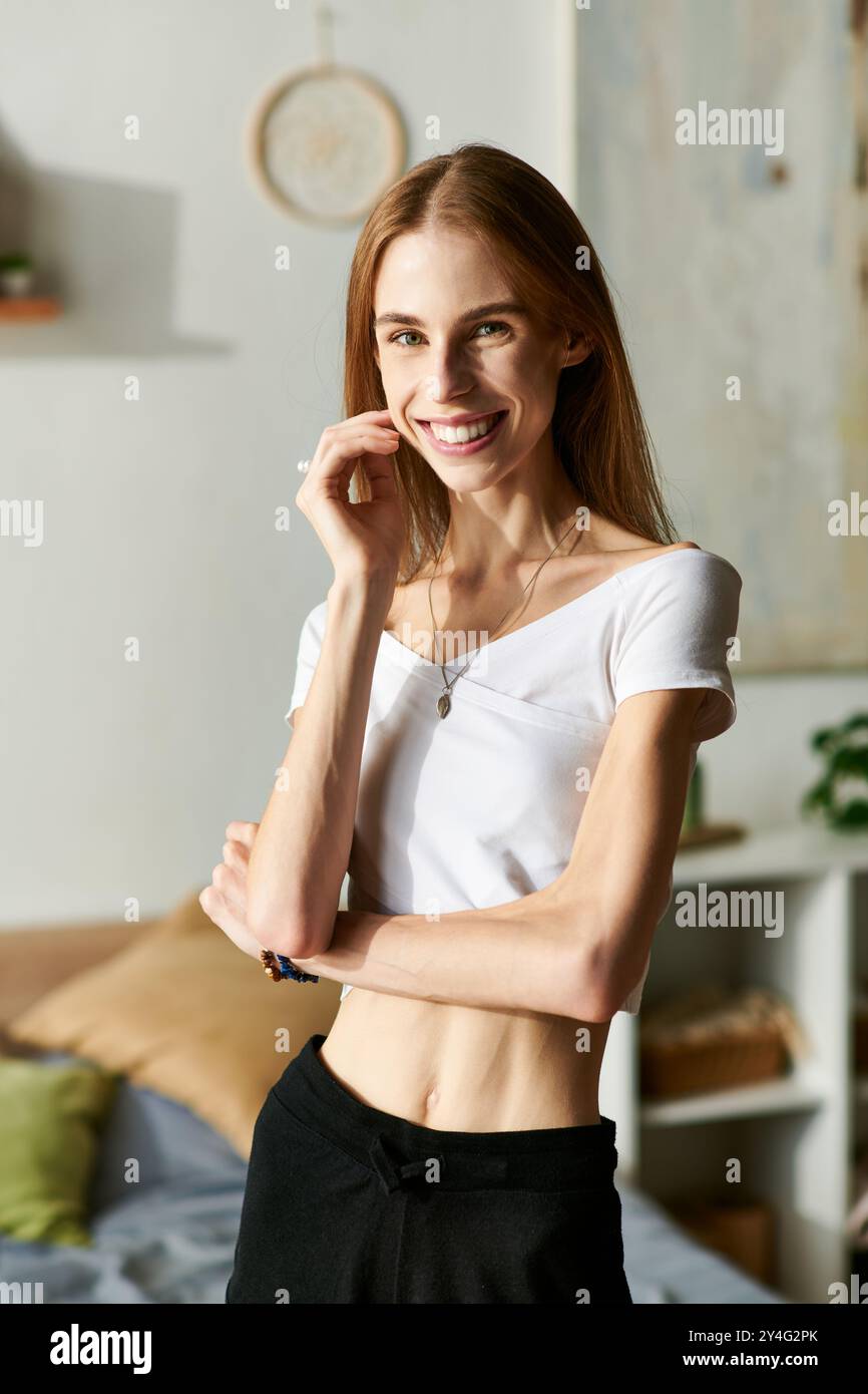 Una giovane donna con disturbi alimentari irradia gioia mentre trascorre del tempo di qualità a casa, mostrando la sua felicità quotidiana. Foto Stock