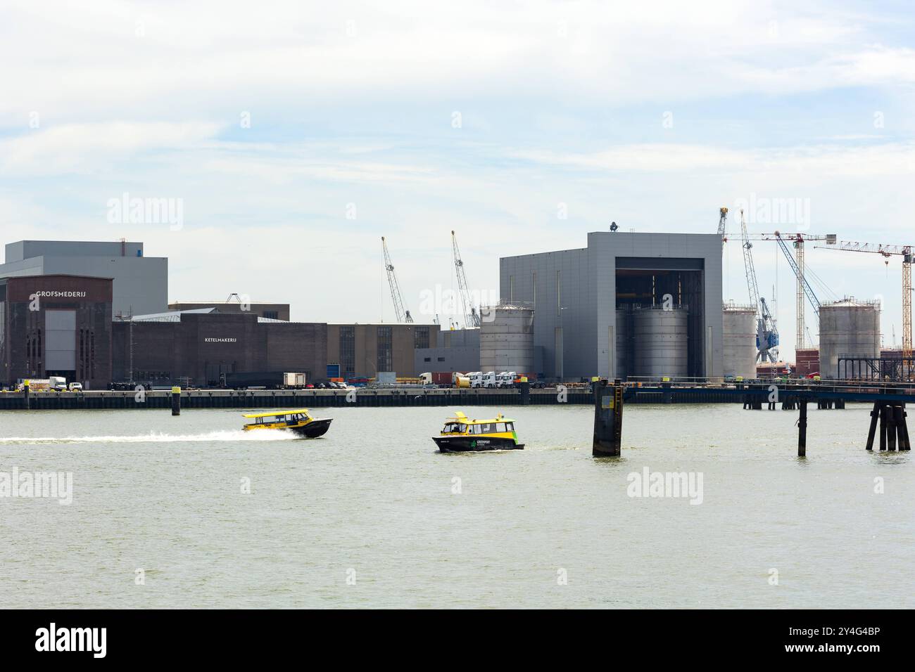 Due taxi d'acqua sul Nieuwe Maas nel porto merci di Rotterdam. Rotterdam, Paesi Bassi - 9 luglio 2004: Due taxi d'acqua sul Nieuwe Maas nel porto merci di Rotterdam. Alcuni magazzini, serbatoi e silo sullo sfondo. Edit_netherlands_rotterdam_Industrial_Port_B97A6708 Foto Stock