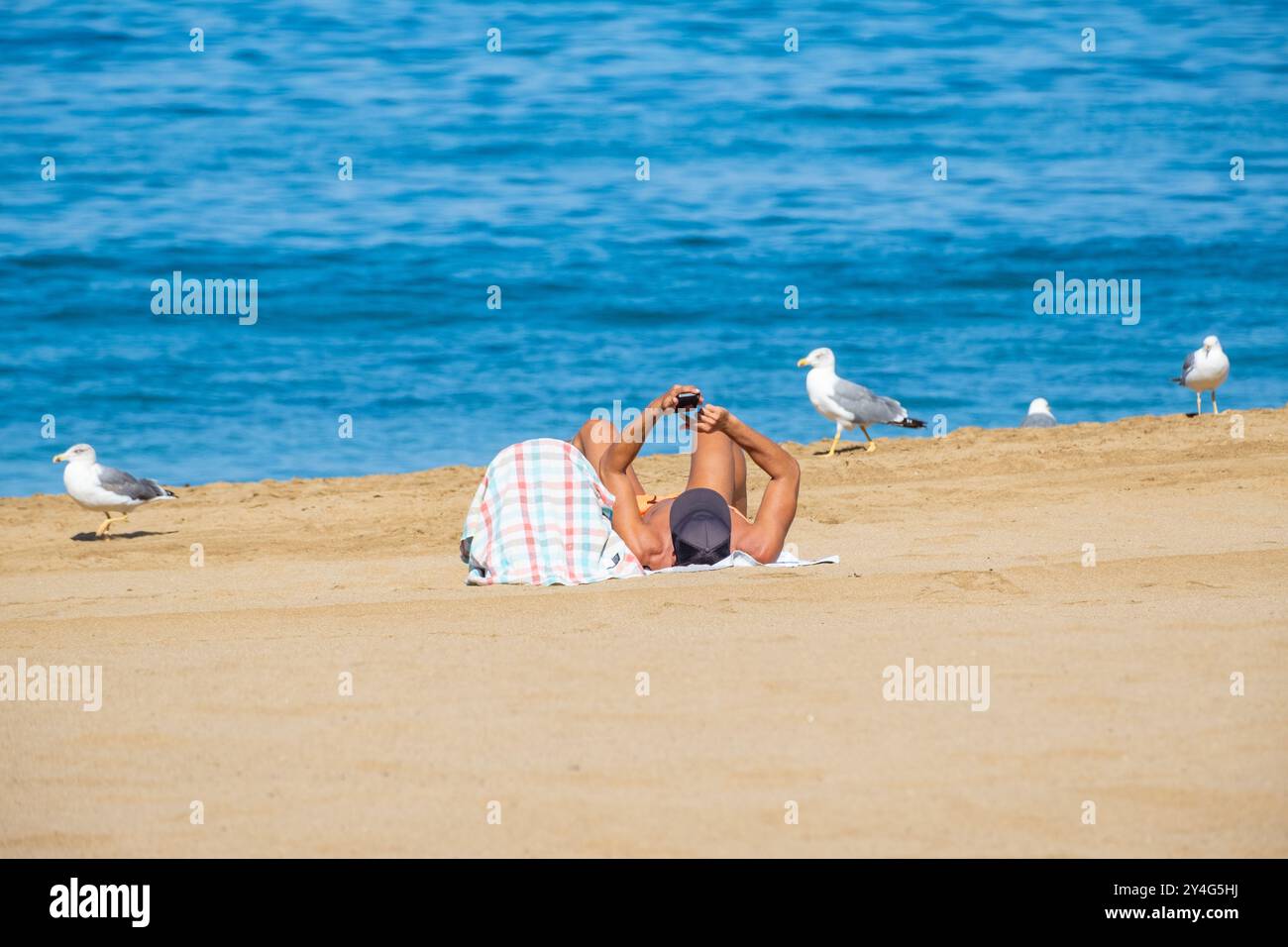Gran Canaria, Isole Canarie, Spagna, 18 settembre 2024. I turisti, molti inglesi, cercano di mantenersi freschi sulla spiaggia della città di Las Palmas quando le temperature raggiungono i 33 gradi Celsius. Crediti: Alan Dawson/Alamy Live News. Foto Stock Gran Canaria, Isole Canarie, Spagna, 18 settembre 2024. I turisti, molti inglesi, cercano di mantenersi freschi sulla spiaggia della città di Las Palmas quando le temperature raggiungono i 33 gradi Celsius. Crediti: Alan Dawson/Alamy Live News. Foto Stock