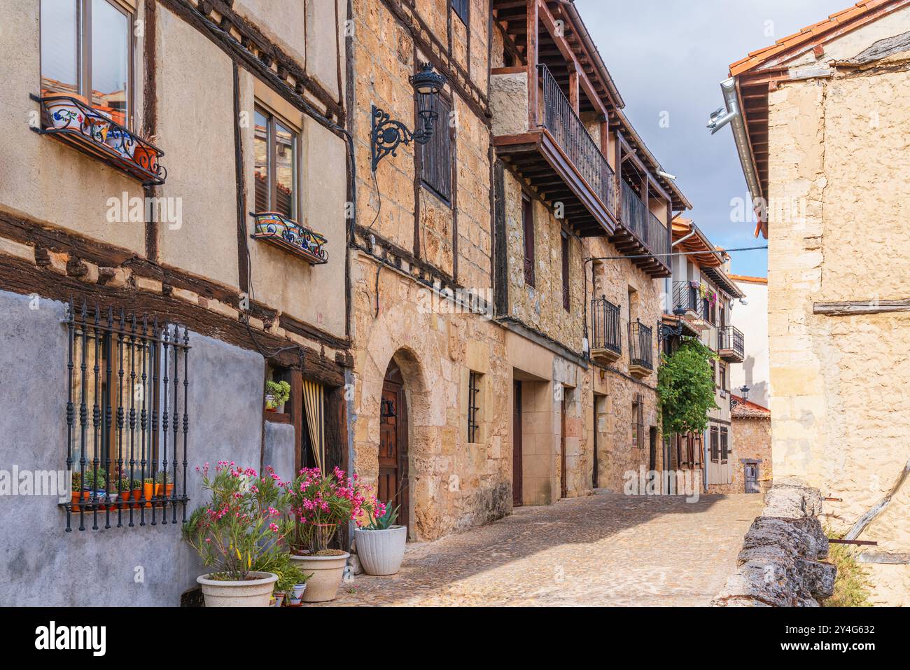 Pittoresca strada che presenta edifici tradizionali decorati con fiori in una città rurale. Frías, provincia di Burgos, Spagna Foto Stock