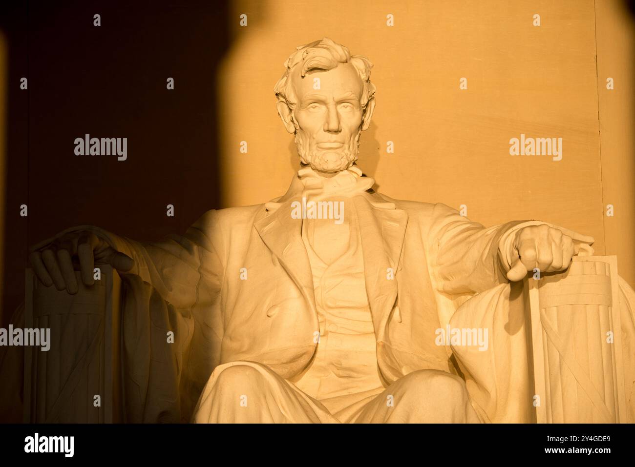 WASHINGTON DC, Stati Uniti: La statua di Abraham Lincoln all'interno del Lincoln Memorial è illuminata dalla luce naturale dorata del sole subito dopo l'alba. Questo effetto luminoso, visibile intorno all'equinozio primaverile e autunnale, esalta la grandezza del monumento mentre il sole splende attraverso l'ingresso orientale. Il Lincoln Memorial, situato sul National Mall, è uno dei monumenti più iconici degli Stati Uniti. NB: Il colore e l'illuminazione sono naturali. Foto Stock