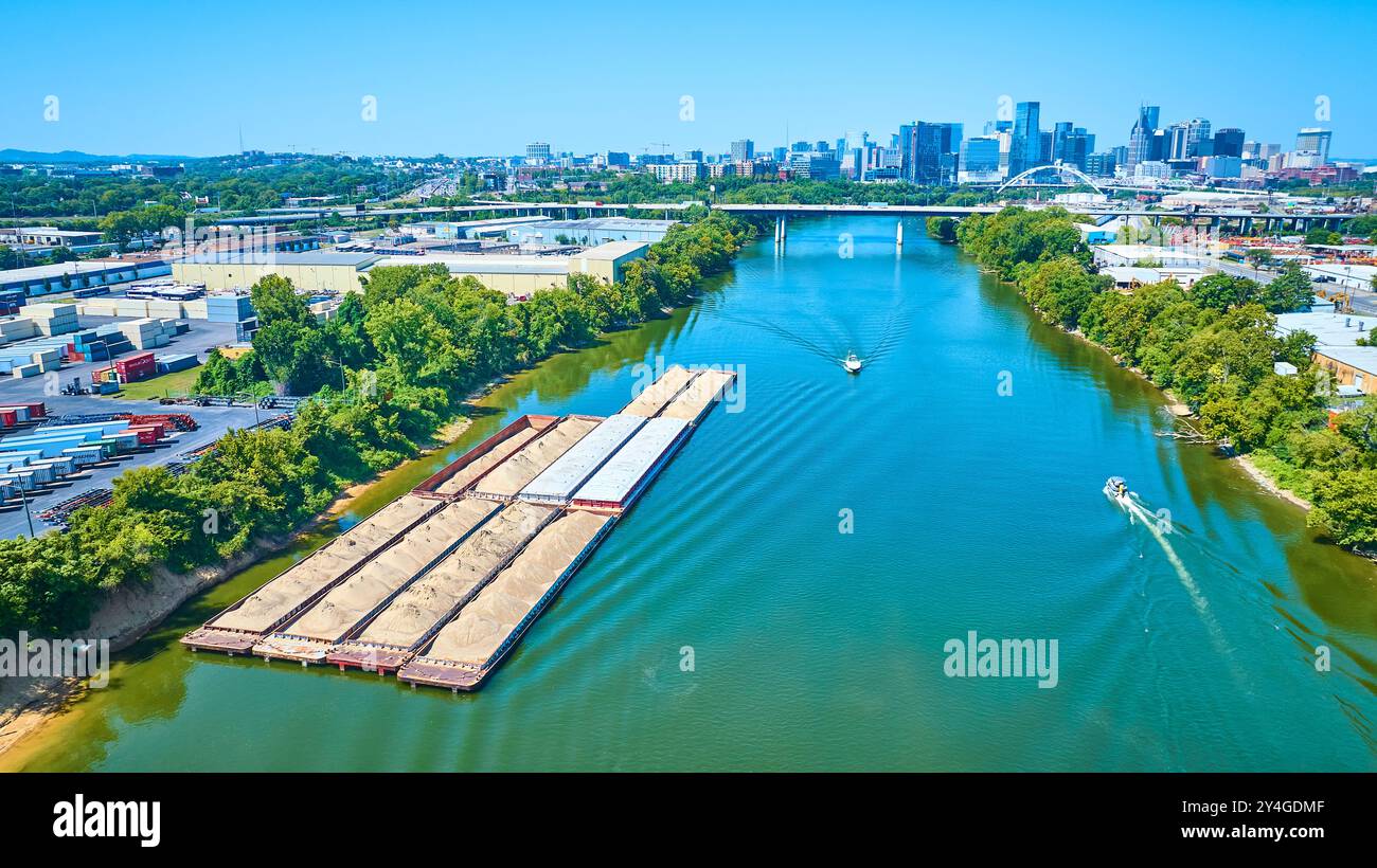Vista aerea delle chiatte sul fiume e dello skyline della città in movimento Foto Stock