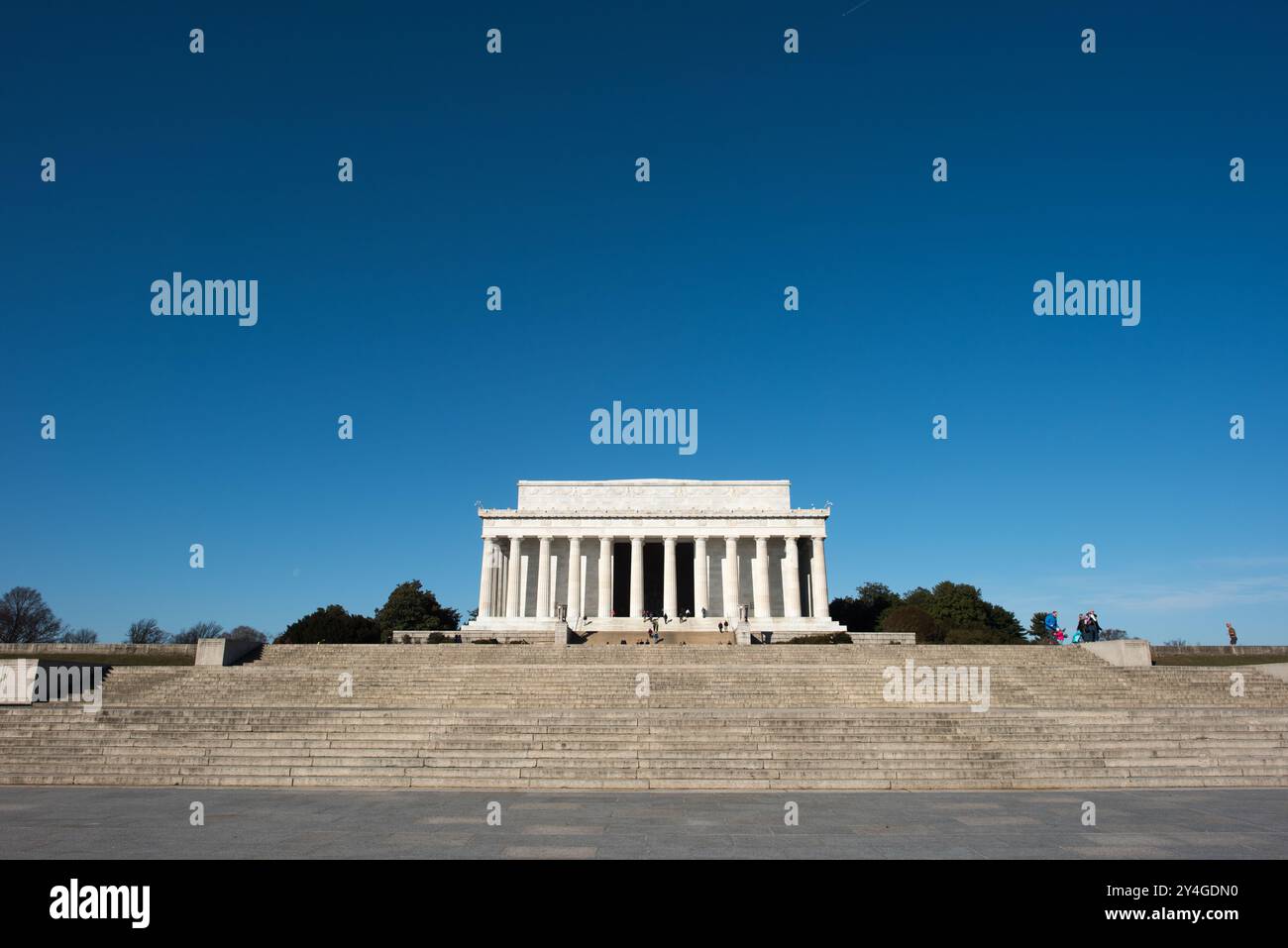 Lincoln Memorial Neoclassical Columns Washington DC // WASHINGTON DC - Una vista grandangolare del lato orientale del Lincoln Memorial, con le sue colonne neoclassiche che si innalzano contro un cielo blu chiaro. Lo scatto cattura la grandezza del monumento dalla piazza, mostrando uno dei monumenti più iconici di Washington DC, progettato dall'architetto Henry Bacon e con una statua dello scultore Daniel Chester French. Foto Stock