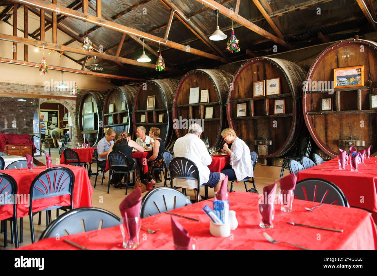 Ballandean Estate Winery Cafe botti di vino Ballandean Australia // BALLANDEAN, Queensland, Australia — grandi botti di vino di quercia fiancheggiano la parete del caffè presso la Ballandean Estate Winery nella regione vinicola del Granite Belt del Queensland. Le botti storiche forniscono sia elementi funzionali che decorativi all'interno dello spazio di ospitalità dell'azienda. Il caffè offre ai visitatori un luogo dove sperimentare la cultura enogastronomica della regione. Foto Stock