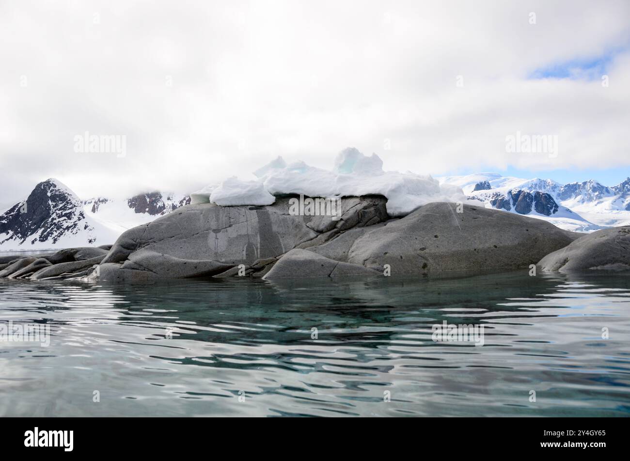 Paesaggio dell'isola di Petermann Penisola Antartica // ISOLA DI PETERMANN, Antartide - Una vista del paesaggio sull'isola di Petermann, situata al largo della costa occidentale della Penisola Antartica. Il terreno accidentato dell'isola è caratterizzato da un mix di affioramenti rocciosi, aree innevate e acque circostanti punteggiate da banchi di ghiaccio. Petermann Island è conosciuta per le sue colonie di Adelie e pinguini gentoo e serve come destinazione popolare per le spedizioni antartiche. Foto Stock