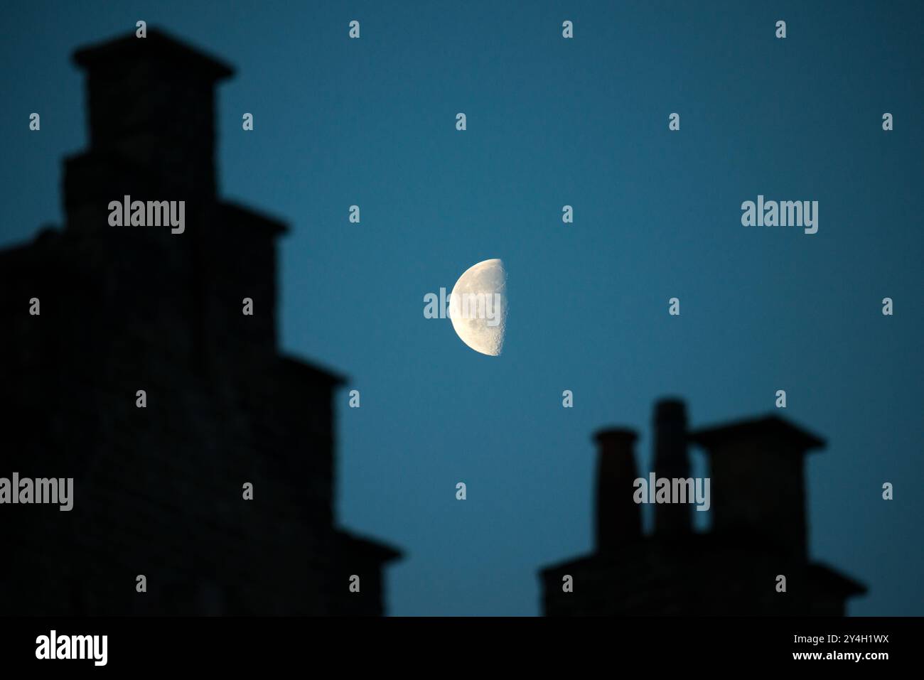 Architettura medievale Moon Bruges Belgio // BRUGES, Belgio - Un terzo quarto di luna illumina i camini storici e le linee dei tetti degli edifici vicino alla piazza Markt centrale di Bruges nelle ore precedenti l'alba. L'architettura medievale sagomata crea un contrasto drammatico con il cielo notturno. Questa suggestiva scena cattura il carattere conservato dello storico paesaggio panoramico della città, patrimonio dell'umanità dell'UNESCO. Foto Stock