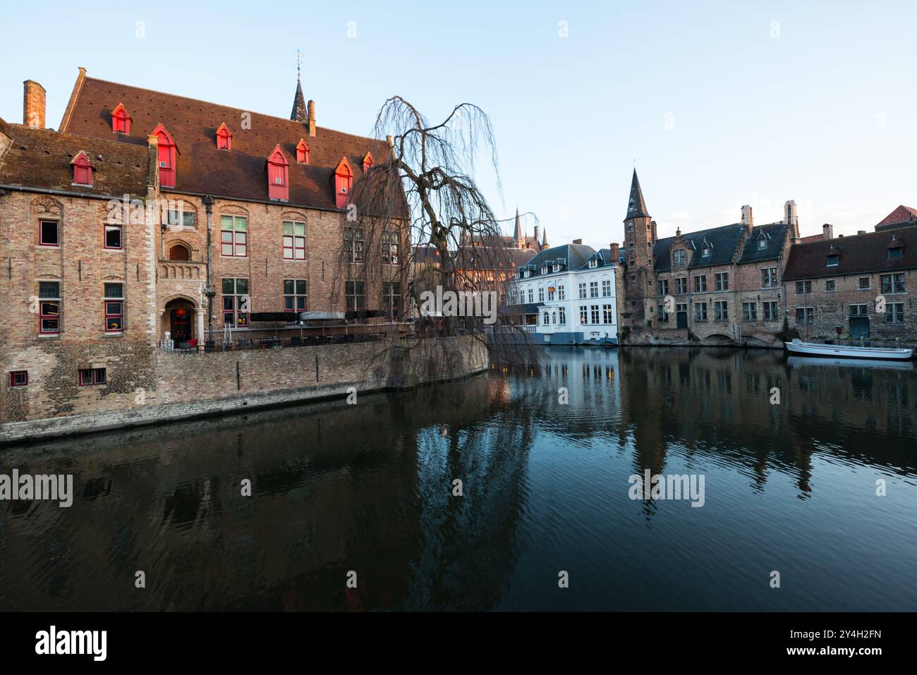 BRUGES, Belgio: I canali medievali di Bruges mostrano la storica rete di canali navigabili della città, fiancheggiata da un'architettura gotica ben conservata. Questi suggestivi corsi d'acqua, che fanno guadagnare a Bruges il soprannome di "Venezia del Nord", riflettono secoli di commercio marittimo e sviluppo urbano. Il sistema di canali rimane centrale per lo status di patrimonio mondiale dell'UNESCO della città. Foto Stock