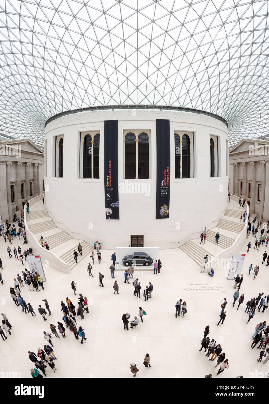 British Museum Queen Elizabeth II Great Court Reading Room London | LONDRA, Regno Unito — La sala di lettura cilindrica si trova nel cuore della Queen Elizabeth II Great Court del British Museum, la sua fascia con iscrizioni visibile sotto il tetto di Norman Foster composto da 3.312 triangoli di vetro di forma unica. La sala fu progettata da Sydney Smirke e aperta nel 1857 come sala di lettura della biblioteca del British Museum, servendo studiosi come Karl Marx e Virginia Woolf prima che la British Library si trasferisse a St Pancras nel 1997. Foto Stock