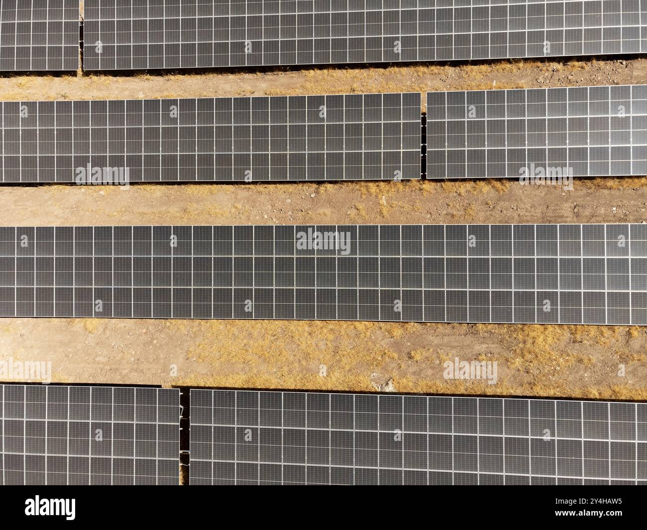 Un drone cattura una vista aerea di file di pannelli solari installati in un campo rurale, mostrando soluzioni energetiche sostenibili per un futuro più verde Foto Stock