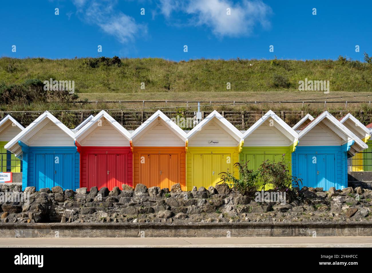 Scarborough, Regno Unito. Una fila di chalet o capanne sulla spiaggia dai colori vivaci sul lungomare di North Bay. Una tradizionale scena costiera inglese Foto Stock