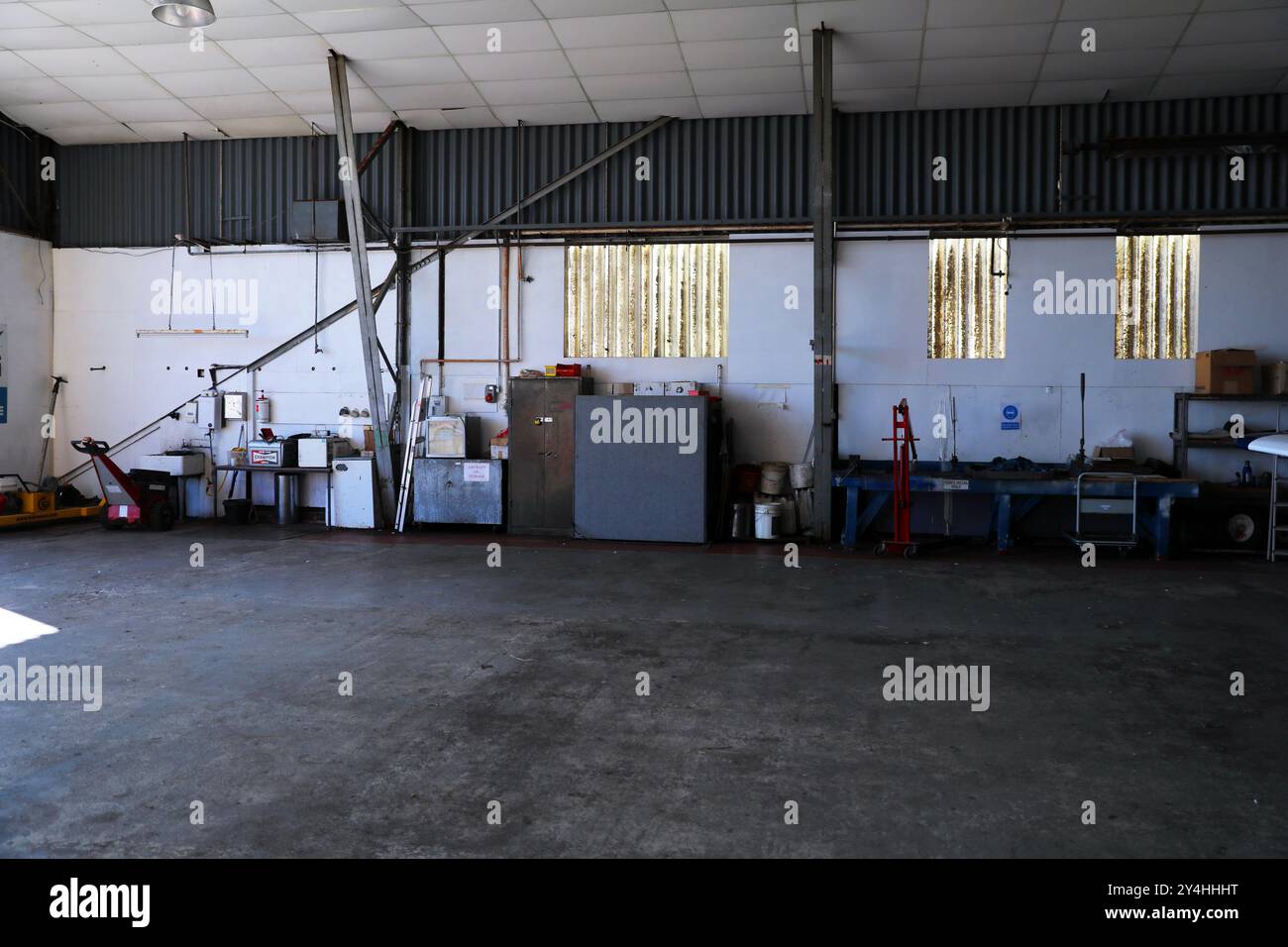 la vista interna di un hangar per aerei, nota il pavimento liscio in cemento e i banchi di lavoro per l'ingegneria Foto Stock