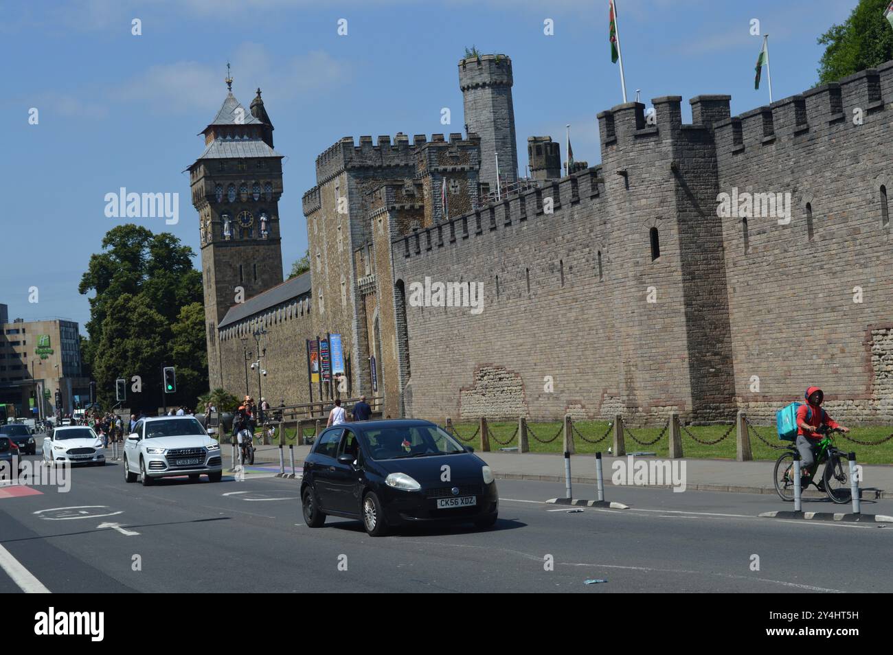 I veicoli oltrepassano la Torre dell'Orologio e le mura del Castello di Cardiff. Cardiff, Galles, Regno Unito. 18 luglio 2024. Foto Stock