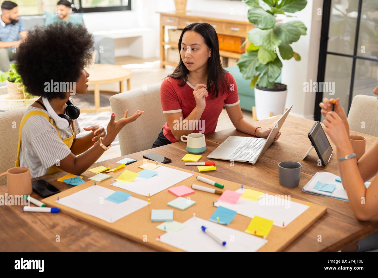 Collaborare al progetto, giovani amici che usano un laptop e appunti a tavola, avviare un'attività Foto Stock