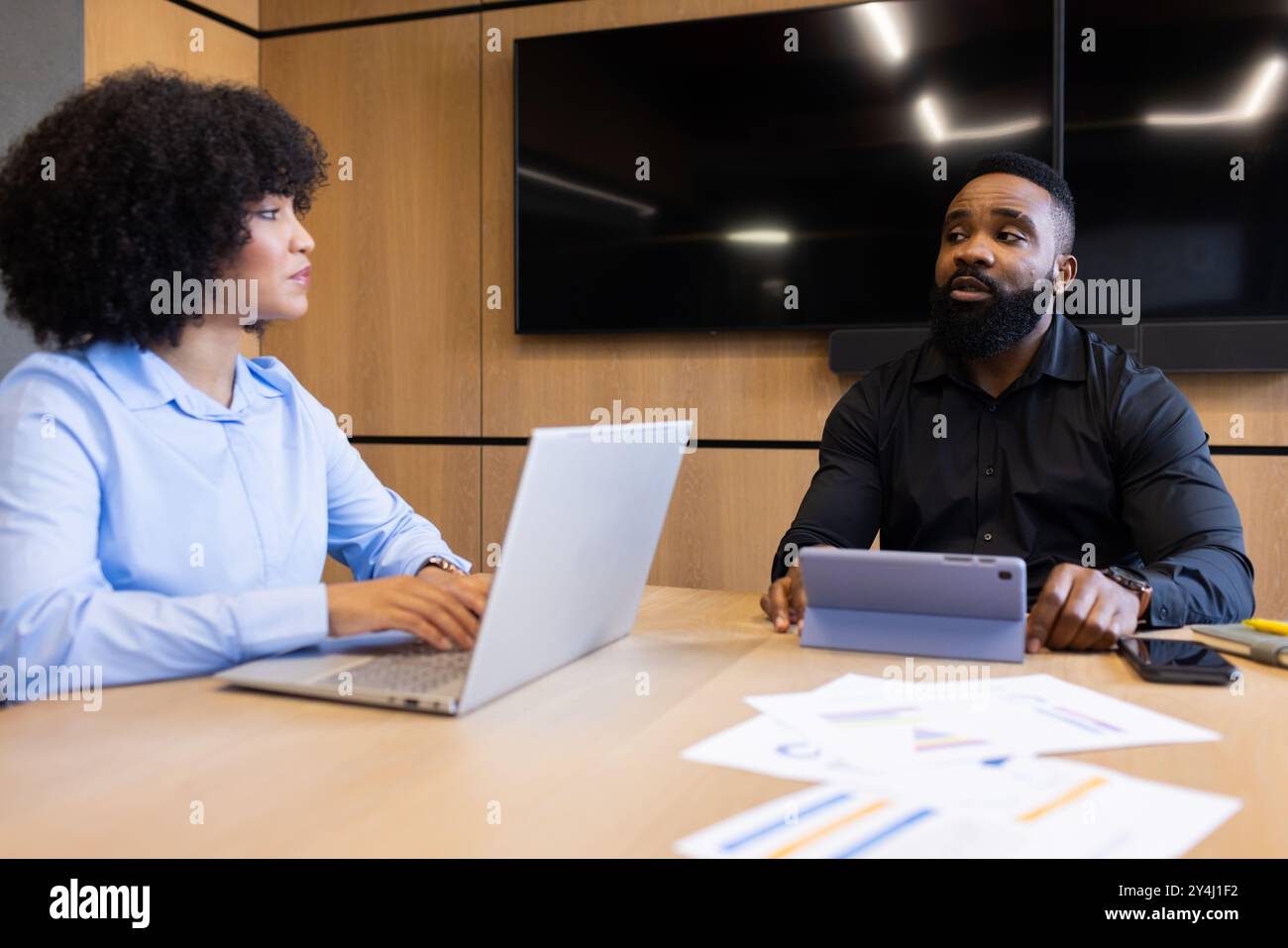 Discussione della strategia aziendale, colleghi che utilizzano notebook e tablet in un ufficio moderno Foto Stock