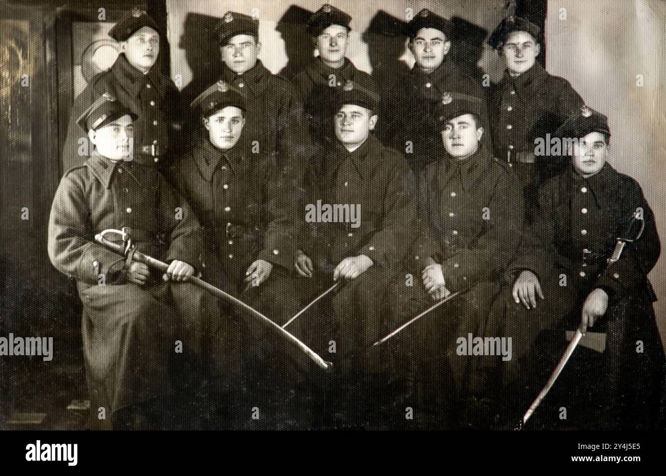 Fotografia d'epoca di un gruppo di soldati in uniforme polacchi che posa per una fotografia che tiene spade in un ambiente formale. Polonia pre-bellica 1937 Foto Stock