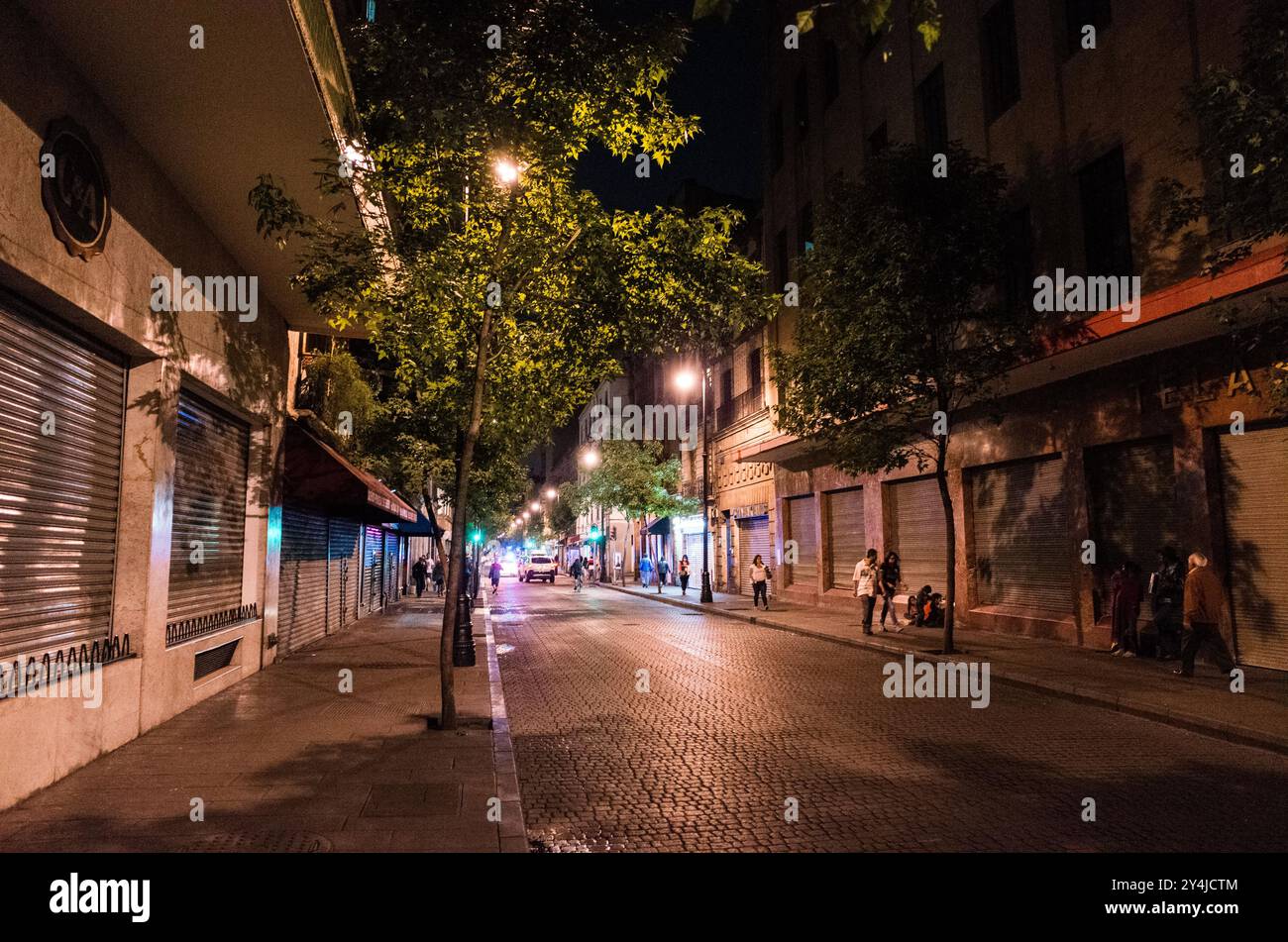 Strada acciottolata vicino a Zócalo città del Messico // CITTÀ DEL MESSICO, Messico — Una strada acciottolata vicino al Zócalo, la piazza principale di città del Messico e una delle più grandi piazze pubbliche del mondo. Il Zócalo, formalmente noto come Plaza de la Constitución, è stato il luogo di ritrovo centrale della città fin dai tempi aztechi, quando era il centro cerimoniale di Tenochtitlan. L'area circostante presenta un'architettura di epoca coloniale e strette strade acciottolate che risalgono al periodo coloniale spagnolo. la piazza è circondata da importanti edifici, tra cui la Cattedrale metropolitana e il Palazzo Nazionale. Messico Foto Stock