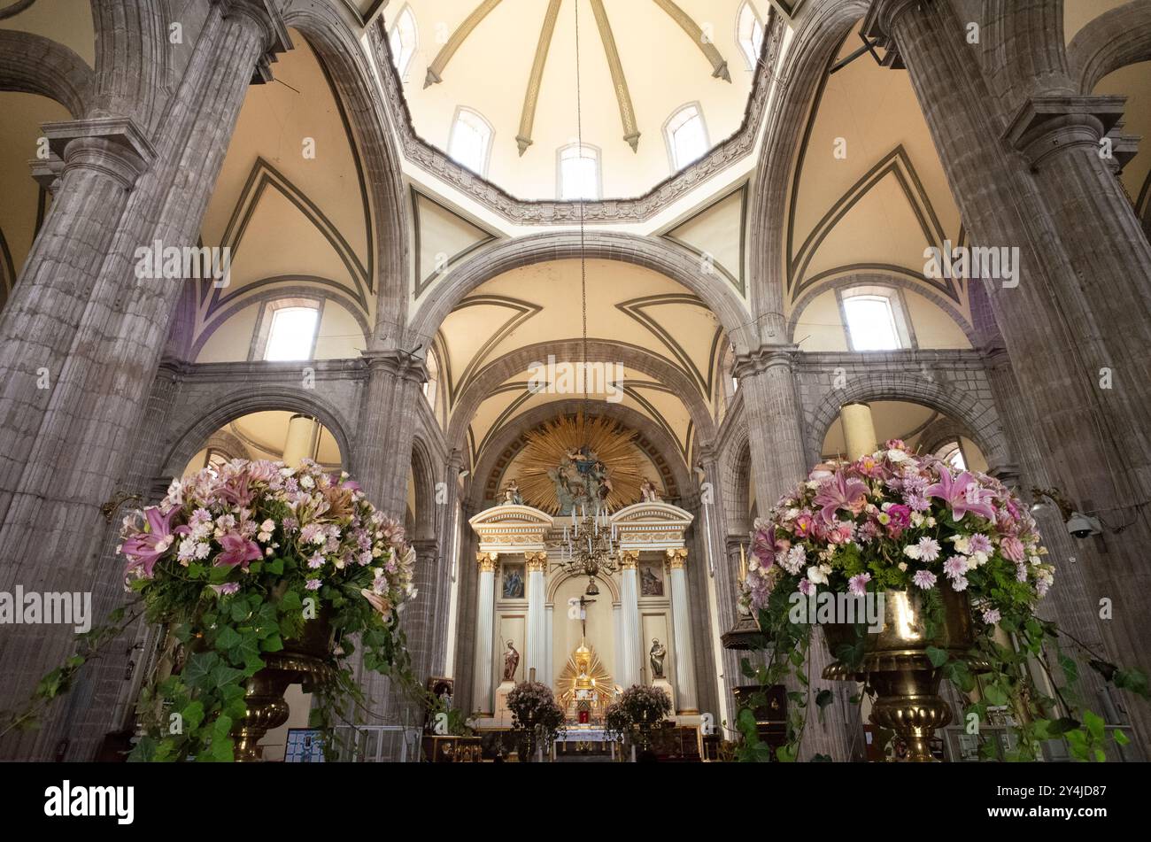 Metropolitan Tabernacle Main Altar città del Messico // CITTÀ DEL MESSICO, Messico — la navata e l'altare principale del Tabernacolo Metropolitano (Sagrario Metropolitano), situato accanto alla Cattedrale metropolitana di fronte al Zócalo. Costruita dall'architetto Lorenzo Rodríguez tra il 1749 e il 1760, la struttura in stile barocco è stata progettata per ospitare gli archivi e i paramenti dell'arcivescovo. Il tabernacolo serviva anche come luogo per amministrare l'Eucaristia e registrare i parrocchiani, funzioni che continua a svolgere oggi. L'edificio rappresenta uno dei più bei esempi di architettura barocca messicana dell'epoca Foto Stock
