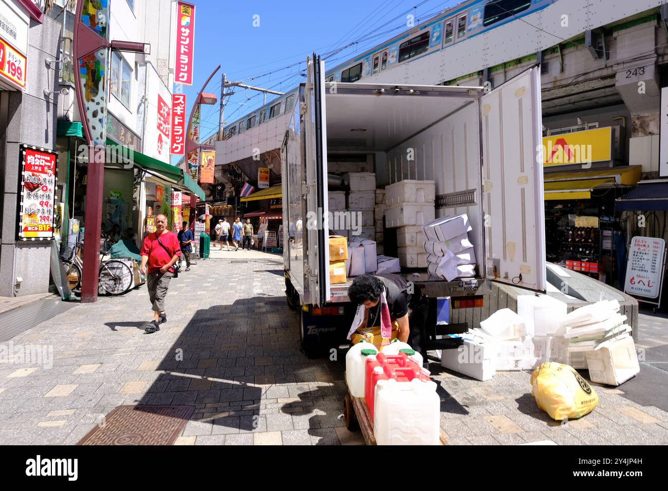 Un camion per le consegne che scarica merci nella via dello shopping Ameyoko a Ueno, quartiere dello shopping Okachimachi, Taito Ward, Tokyo, Giappone Foto Stock