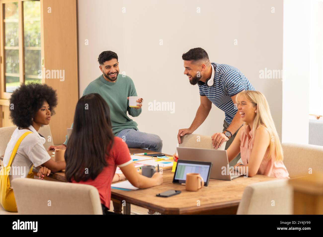 Start up business, collaborazione al progetto, gruppo di giovani amici che lavorano insieme a tavola Foto Stock