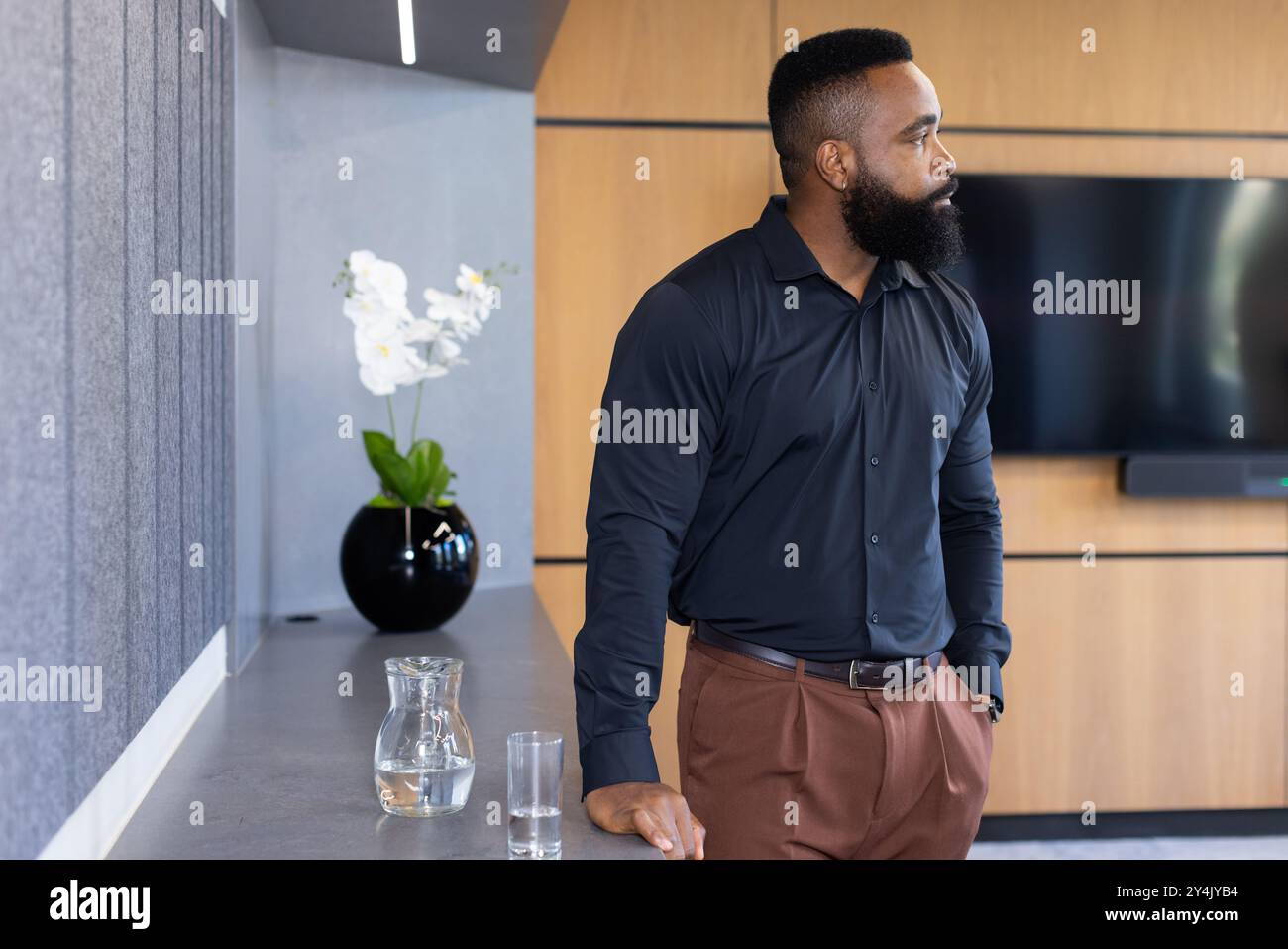 In ufficio, professionale con un aspetto attento, caraffa d'acqua e vetro Foto Stock