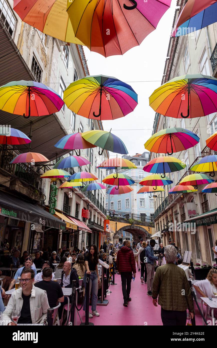 Pink Street è anche conosciuta come Umbrella Street per la tettoia di ombrelli colorati che pendono sopra la testa a Lisbona, Portogallo Foto Stock