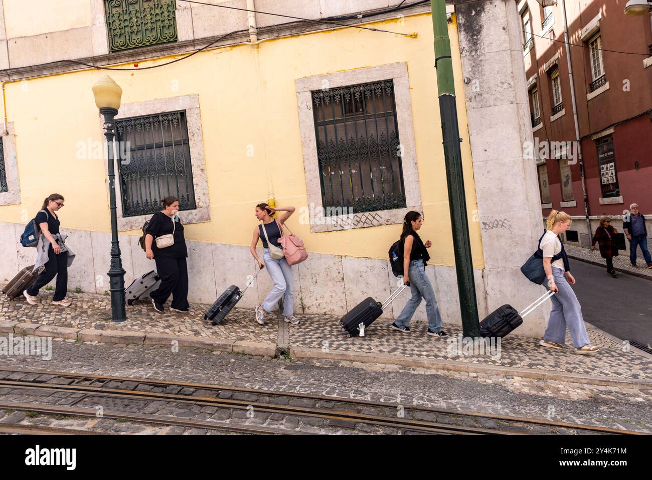 Gli studenti universitari depositano in una strada ripida con i loro bagagli a Lisbona, in Portogallo, dopo aver terminato il mandato. Foto Stock