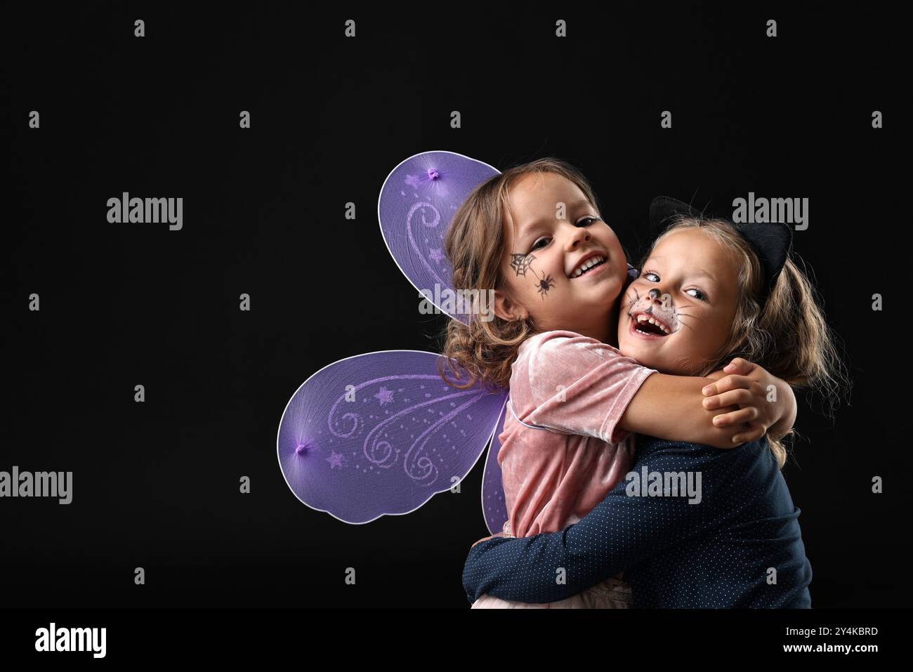 Ragazze divertenti che indossano costumi su sfondo nero, spazio per il testo. Festa di Halloween Foto Stock