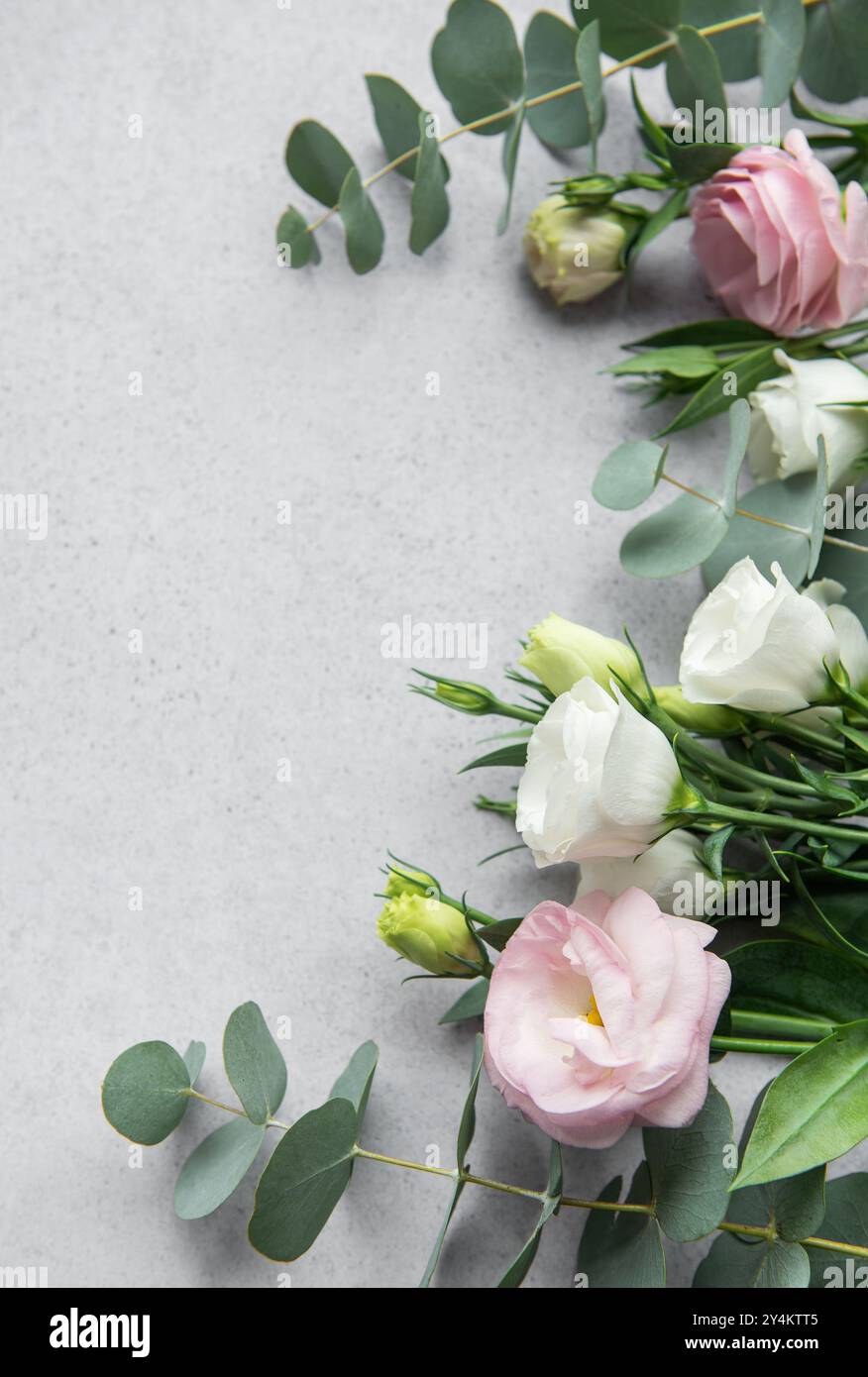 Un bellissimo assortimento di fiori rosa, bianchi e crema sono abilmente disposti con foglie di eucalipto, creando una composizione elegante perfetta per flo Foto Stock