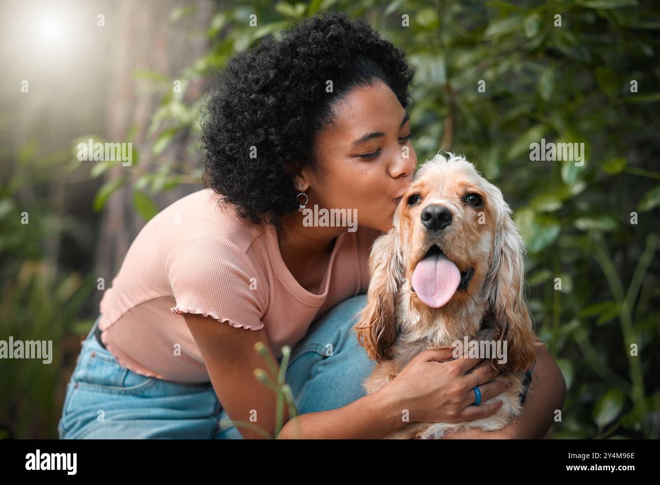 Donna, cucciolo di spaniel e bacia nel parco con sorriso, abbraccio e cura a terra in estate. Ragazza, cane mamma e felice di abbracciare con animali domestici, animali o. Foto Stock