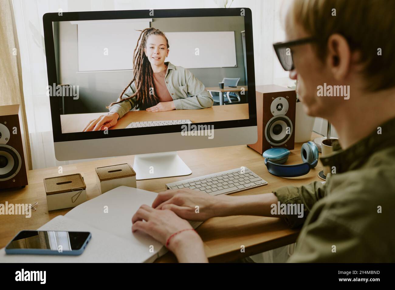 Vista a spalla di un uomo irriconoscibile che legge un libro in Braille seduto al tavolo di lavoro Foto Stock