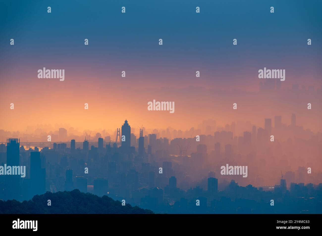 Una vista panoramica dello skyline di Taipei dopo la pioggia. Il sole che tramonta proietta un caldo bagliore sul paesaggio cittadino, creando spettacolari silhouette di skyscra Foto Stock