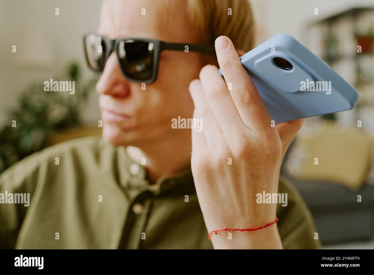 Primo piano medio di smartphone blu in mano a un uomo con disabilità Foto Stock