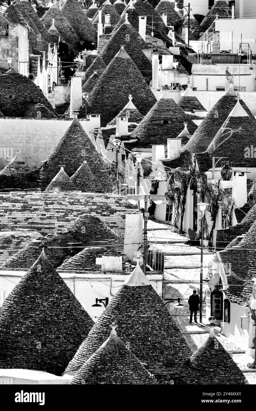 Una veduta aerea in bianco e nero della principale via dello shopping tra le case dei trulli del Rione Monti, Alberobello, Italia. Foto Stock