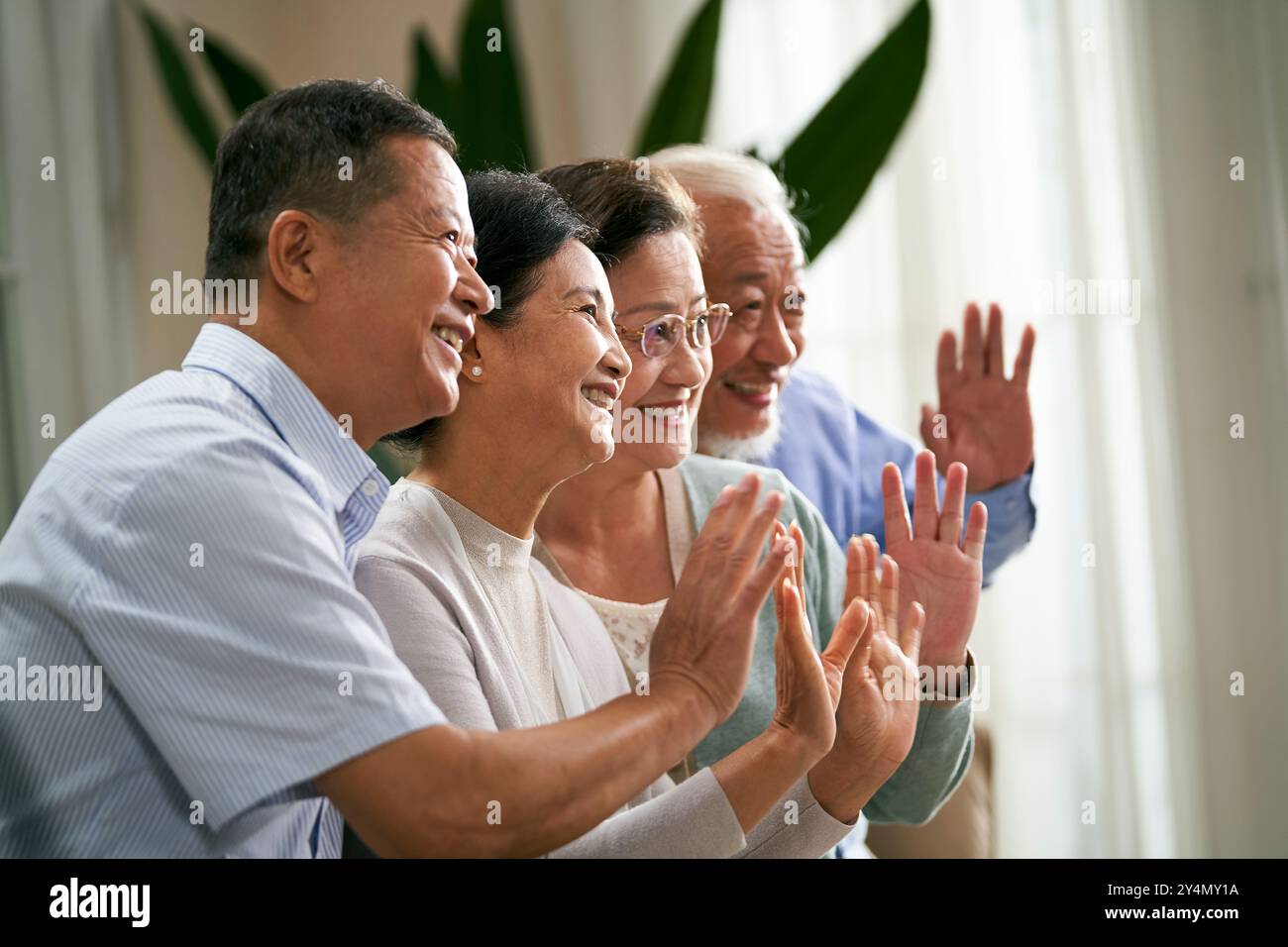 gruppo di persone asiatiche senior felici due coppie che saltano le mani e salutano amici o familiari durante la videochat Foto Stock