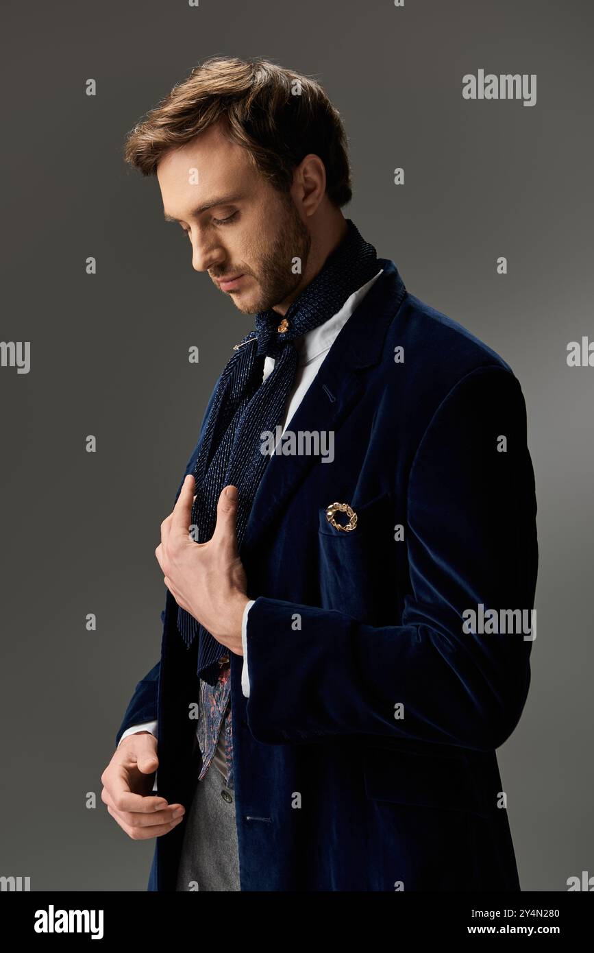 Un uomo vestito impeccabilmente adatta il suo abbigliamento, trasuda fascino e raffinatezza in un'atmosfera regale. Foto Stock