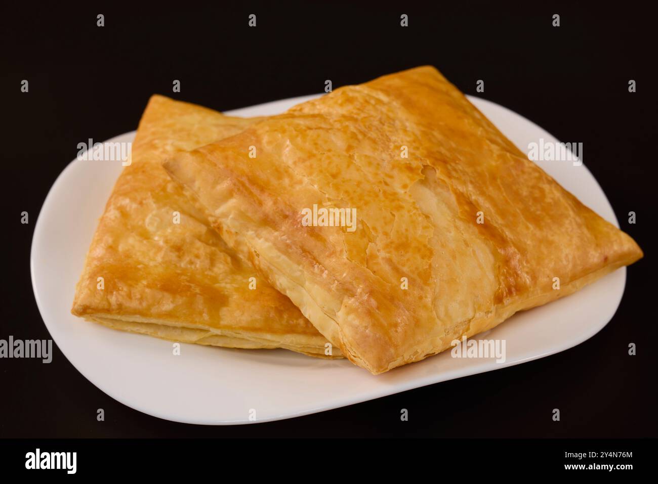 (Merdenea) torta di formaggio su un piatto bianco su sfondo nero. Foto Stock