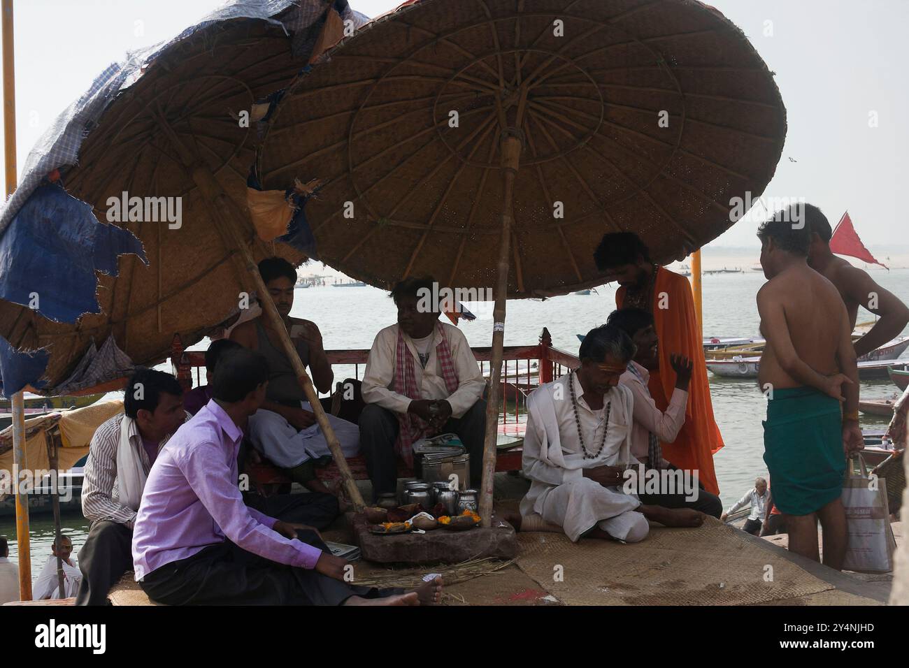 Varanasi, Uttar Pradesh / India - 9 maggio 2015 : persone sedute all'ombra e occupate nelle loro attività sul Varanasi ghat. Foto Stock