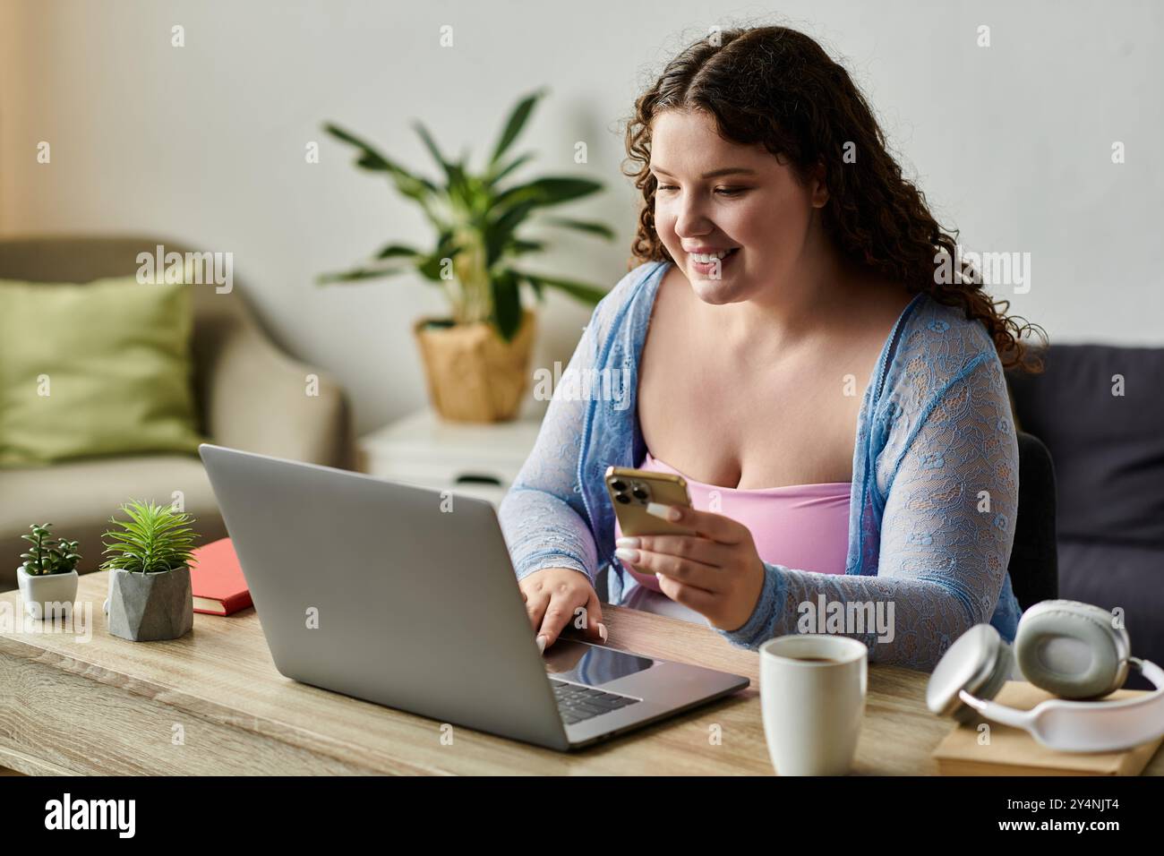 Donna positiva con capelli scuri che lavora a casa. Foto Stock