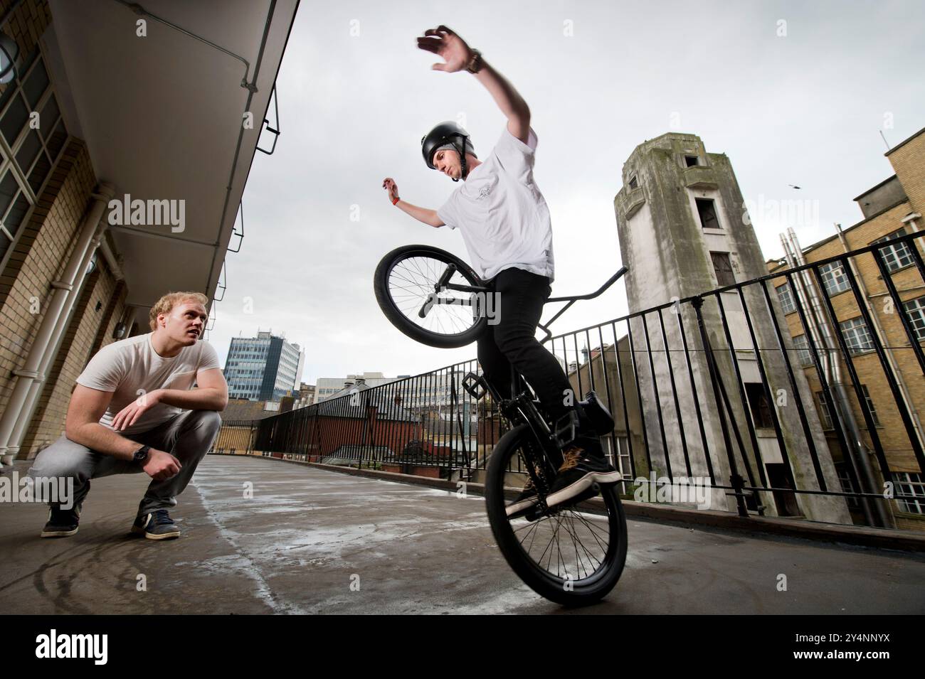 Matti Hemmings esegue una acrobazia BMX "D Truck" su un balcone dell'edificio della Old Fire Station di Bristol. Foto Stock