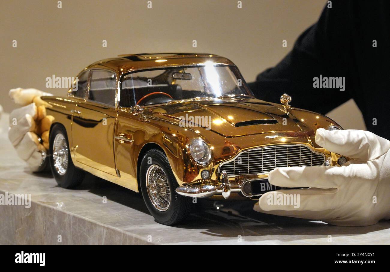 Un modello placcato oro 24 carati della Goldfinger Aston Martin DB5 di James Bond, al prezzo di £ 24.999 e uno dei soli sette prodotti in scala 1:8 dai produttori britannici di kit per auto Agora Models, in mostra al Burlington Arcade nel centro di Londra. Creato in collaborazione con 007 registi, Eon Productions e Aston Martin per celebrare i 60 anni del film di James Bond Goldfinger del 1964, il modello viene fornito con alcuni dei gadget più famosi di Bond, tra cui un sedile con eiettore funzionante e una targa girevole. Data foto: Giovedì 19 settembre 2024. Foto Stock