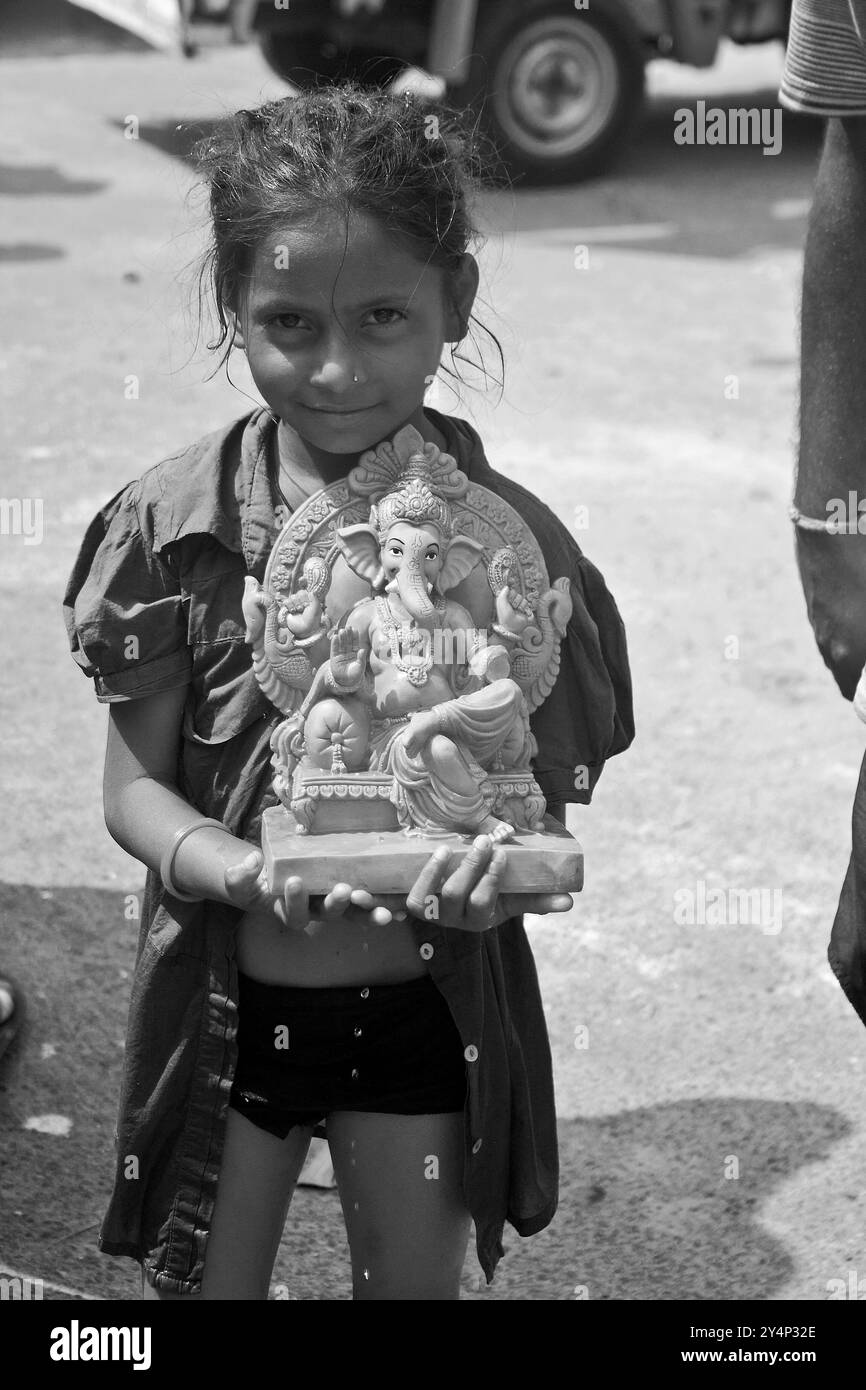 Vadodara, Gujarat / India - 27 settembre 2015 : Una bambina porta la statua del Signore Shree Ganesha sulla sua mano in un giorno di festa Ganesha. Foto Stock