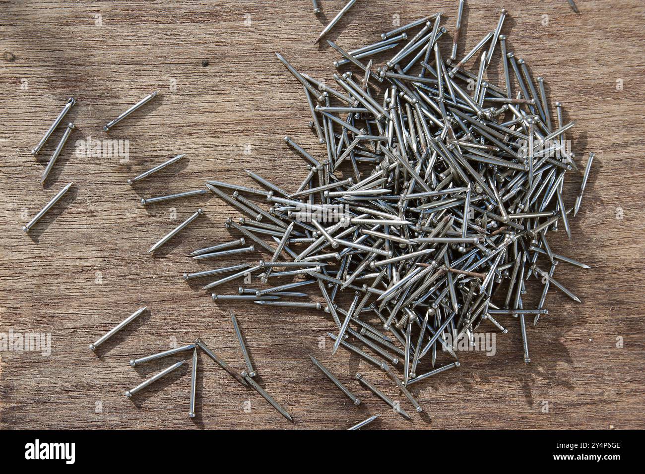 Vadodara, Gujarat / India - 3 maggio 2017 : Un mucchio di chiodi metallici su fondo marrone in legno. Foto Stock