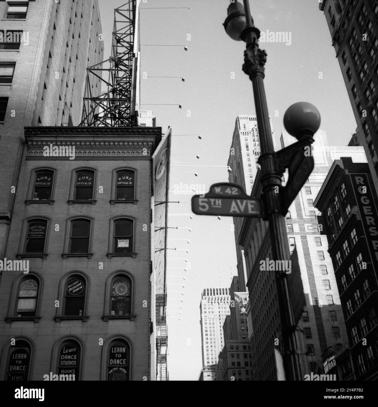 Scene di strada, pedoni ed edifici all'intersezione tra la 5th Avenue e la 42nd Street West a New York City c. 1960. Foto Stock