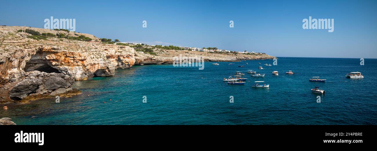 Barche turistiche raccolte fuori dagli ingressi delle grotte vicino a Santa Maria di Leuca nella provincia di Lecce, Puglia, Italia Foto Stock